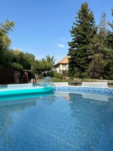 a swimming pool with a water slide in a yard at Kulcs a Kulcshoz Menedék in Kulcspuszta