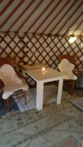 a white table and two chairs in a yurt at Mongolische Jurte auf Landhof inmitten der Natur bei Lübeck in Selmsdorf