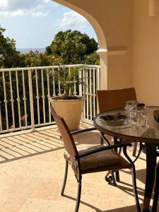 a patio with a table and chairs on a balcony at Royal Apartments 1 bedroom apartment sea views in Saint James