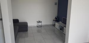 ein Wohnzimmer mit Couch und Fernseher in der Unterkunft studio Blue Honey 972 in Quartier Châteauboeuf