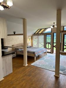 a bedroom with a bed in a room with windows at Карпатський Замок in Rozluch