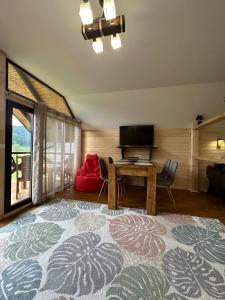 a living room with a table and a television at Карпатський Замок in Rozluch