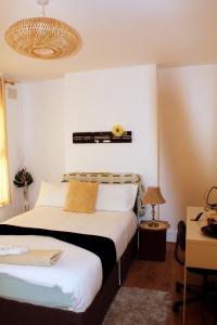 a bedroom with two beds and a chandelier at Spacious 4-Bed House - Sleeps 5 Garden & Parking in London