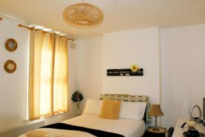 a bedroom with a bed and a window at Spacious 4-Bed House - Sleeps 5 Garden & Parking in London