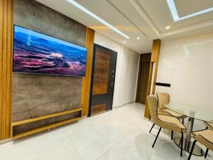 a dining room with a table and a painting on the wall at Lusail in Beni Mellal