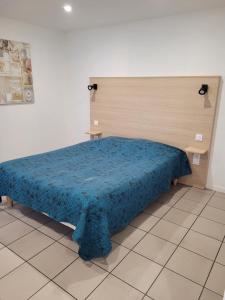 a bedroom with a bed with a blue blanket at Le Saint Benoist in Aizenay