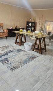 a living room with two tables and a rug at CenoeN Country Suites in Rooipoort