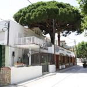 a house with a tree in front of it at Hotel la Masia in Portbou