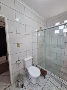 a bathroom with a toilet and a glass shower at Loft de Quarto e Sala em Vila in Belém +3 photos