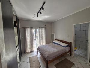 a bedroom with a bed and a bathroom with a window at Loft de Quarto e Sala em Vila in Belém
