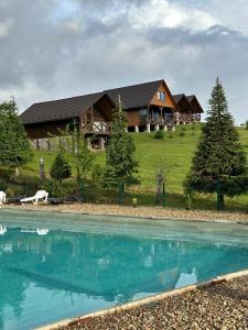 a large house with a pool in front of it at Карпатський Замок in Rozluch