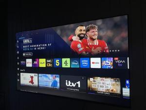 a television screen with two soccer players on it at Stylish Two Bedroom Apartment in Cardiff +10 photos