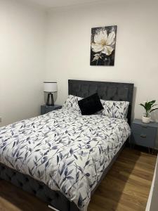 a bedroom with a bed with a flower picture on the wall at Stylish Two Bedroom Apartment in Cardiff