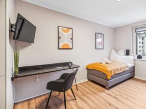 a bedroom with a bed and a desk and a tv at Modernes 2 Zimmer Apartment mit Balkon, zentrale Lage in Bremen