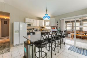 オーシャン・パインズにあるSpacious Family Home 9 Mi to Ocean City Boardwalkの白い家電製品と黒いバースツールを備えたキッチン
