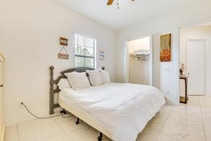 a white bedroom with a bed with white sheets and pillows at Day Trip to Fort Myers Beach Pet-Friendly Home! in Lehigh Acres