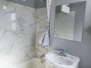 a white bathroom with a sink and a mirror at Melsask Motel in Melville +37 photos