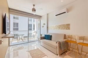 un salon avec un canapé et une table dans l'établissement U-GO Sui Loft : Luxe et Confort face à la Mer à Santa Marta, à Playa Bello Horizonte