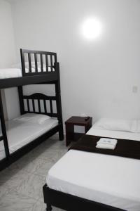 OcañaHotel San Cayetano的带两张双层床和两张桌子的房间