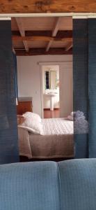 Una vista de un dormitorio con una cama y un espejo. en NAMOR-Estudio Galeria, en Ribadeo 1 foto más