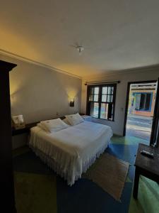 a bedroom with a bed and a large window at Casa 1915 Pousada in Morretes +31 photos
