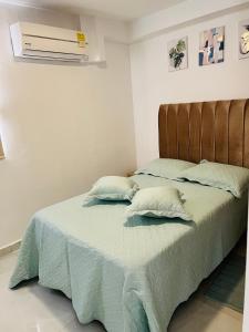 a bed with two pillows on it in a bedroom at Apartamento Marbella Piso 28 - Playa in Cartagena de Indias
