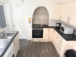 a kitchen with a stove and a microwave at Serene Suite Room 4 in Southampton