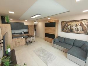 una sala de estar con un sofá y una mesa en Kisterasz Apartman, en Balatonalmádi