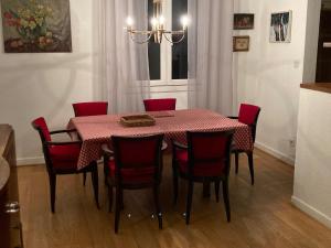 a dining room with a table and red chairs at Komfortables Haus mit Terrasse und Garten in Collioure
