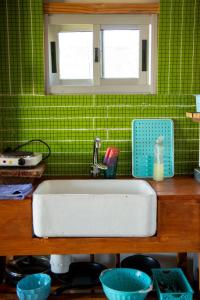 a white sink in a kitchen with green tiles at Uy MÁGICA Cabaña en entorno Natural único in Mercedes