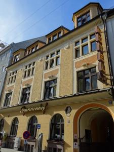 ein gelbes Gebäude mit einem Schild an der Seite in der Unterkunft Brunnenhof City Center in München