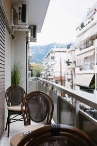 two chairs and a table on a balcony with a view at DON Luxury Living Volos in Volos