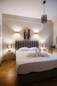 a bedroom with a large white bed with two lamps at DON Luxury Living Volos in Volos +43 photos