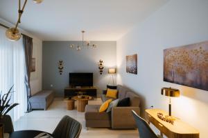 a living room with a couch and a tv at DON Luxury Living Volos in Volos