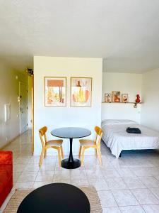a room with a bed and a table and chairs at Studio lumineux piscine/plages in Mandelieu-la-Napoule