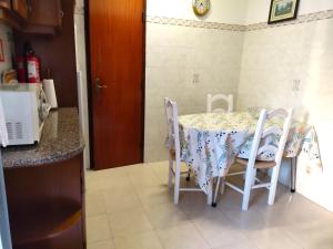 a kitchen with a table and chairs in a kitchen at Pacheco's Guesthouse in Lagos +9 photos