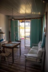 a room with a table and a bed and a table and chairs at Uy - ROMÁNTICA Cabaña en entorno Natural único in Mercedes