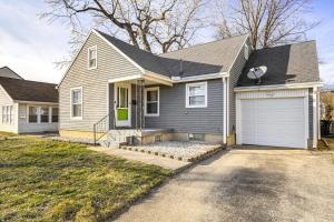 デイトンにある2 Mi to UD Pet-Friendly Home with Fenced Yard!の白いガレージのある灰色の家