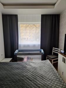 a bedroom with a bed and a window and a chair at Mõisavahe apartment in Tartu