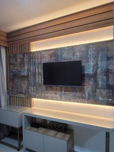 a living room with a television on a wall at Home Design Club in Sobral +21 photos