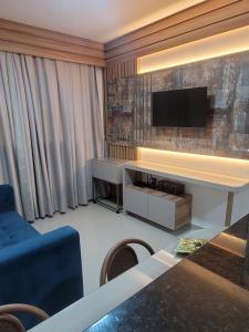 a living room with a couch and a tv on a wall at Home Design Club in Sobral