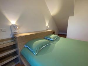 a bedroom with a green bed with two pillows at Casa di Gabry in Gradisca dʼIsonzo