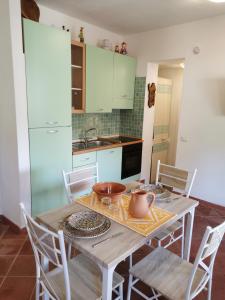 a kitchen with a wooden table with chairs and a sink at Live Sea and Nature in Costa Paradiso