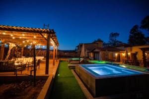 ein Garten mit Swimmingpool und Pergola in der Unterkunft Emmalu Hotel Boutique in San Marcos