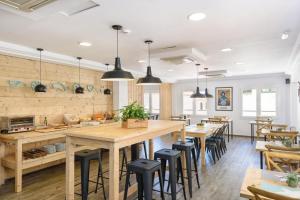 马翁Hostal Jume - Urban Rooms的一间有大木桌和椅子的餐厅