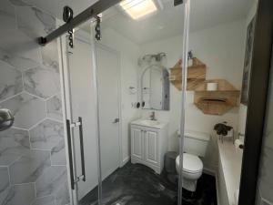 a bathroom with a shower and a toilet at Two fully independent unit - a modern house and a private apartment, each with its own entrance, located just 15 min from Sea-Tac Airport and 5 min from Des Moines Marina in Des Moines