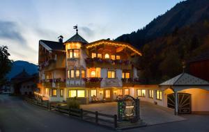 a large building with lights on in the evening at Ferienschlössl Harmonie in Holzgau