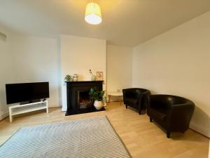 a living room with two chairs and a fireplace at Private City Centre Apartment in Waterford