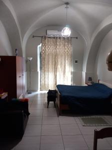 a bedroom with a blue bed and a window at La civita 1 in Catania
