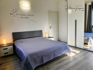 a bedroom with a bed with a blue bedspread on it at Palazzina Trevigiana 2 king Size Near Station And Venice in Treviso